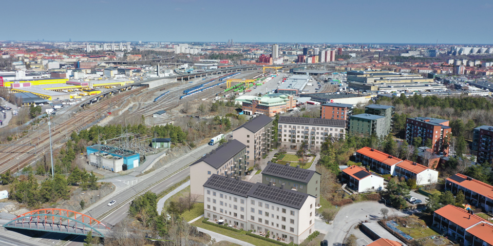 Flygvy över planförslaget och utsikt över ett stort område med järnvägsspår och vy in mot Stockholm