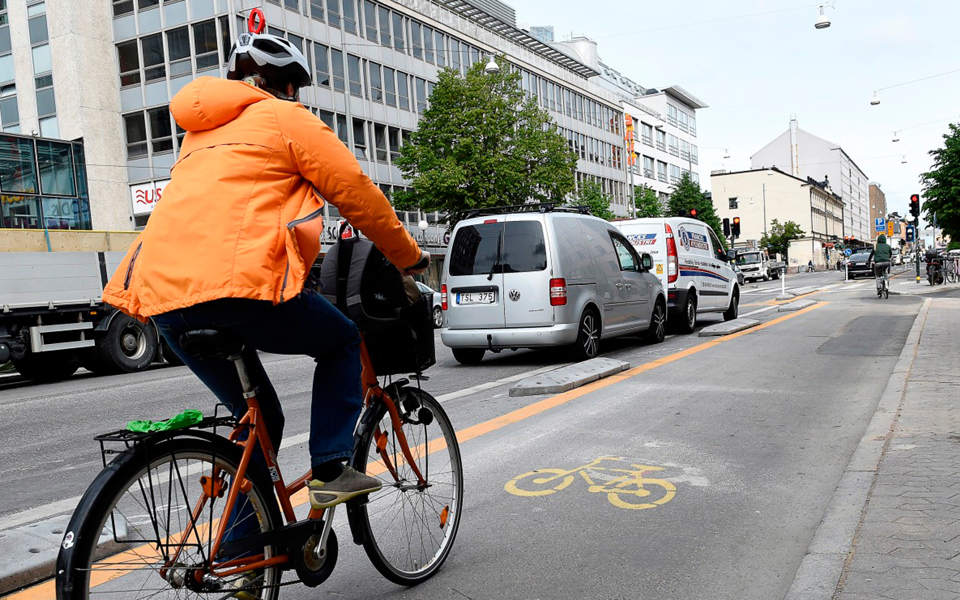 En person som cyklar i cykelbanan parallellt med körbanan på Götgatan, foto.