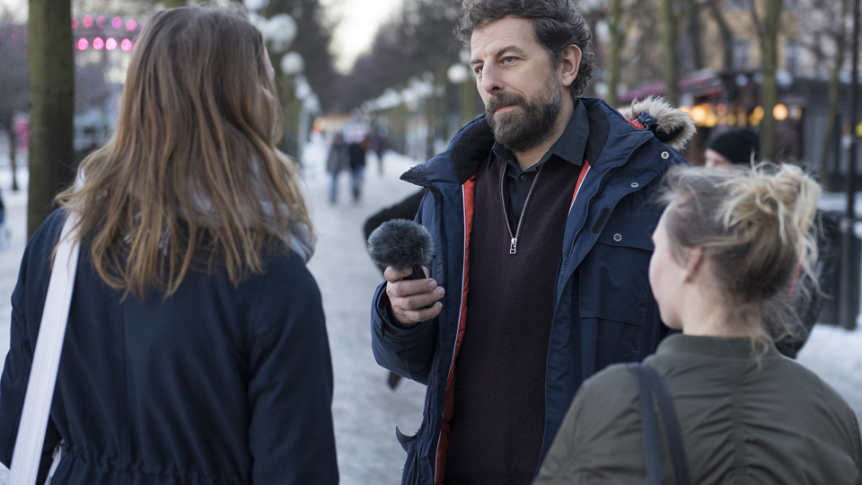 En man intervjuar två kvinnor. Man ser kvinnorna bakifrån.
