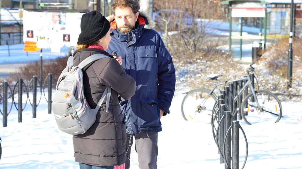 En man intervjuar en kvinna med ryggsäck.