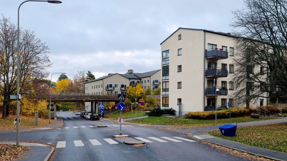 Gata med bro för tunnelbanetrafik över, till höger syns flera flerbostadshus, fotomontage.