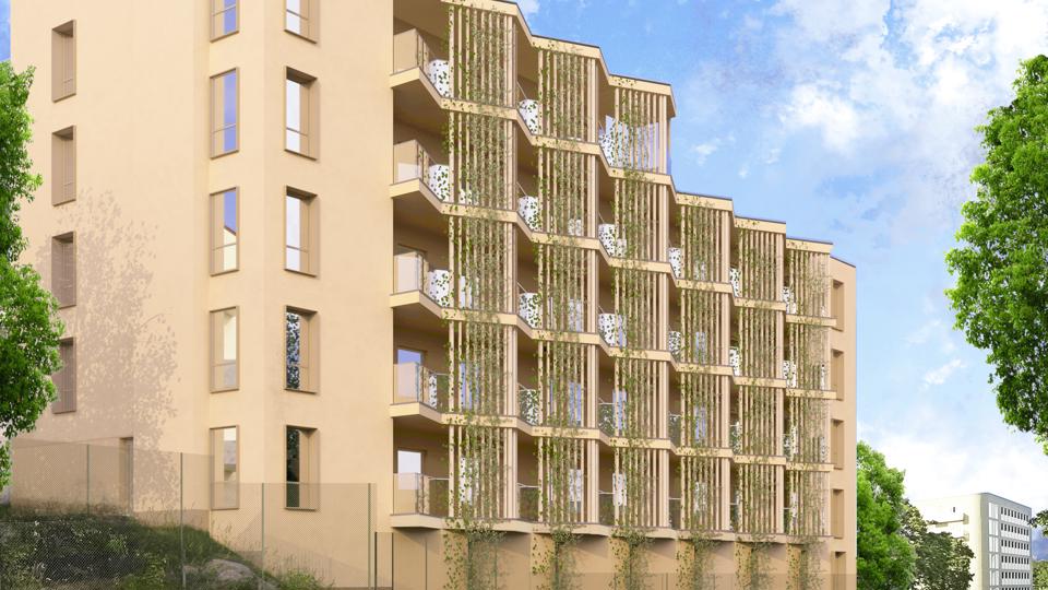 Visionsbild. Fasaden är i ljust trä med växter som klättrar i ribborna. Ett tunnebanetåg passerar framför huset. Det är ljust och soligt i bilden.