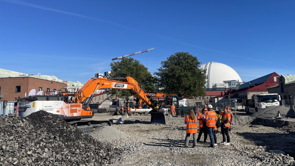 Fållanparken under finentreprenad med eldriven grävskopa och Globen i bakgrunden mot öster. 