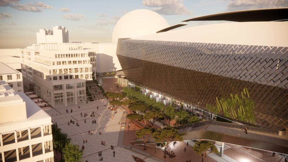 En flygvy över ett torg omgärdat av vita flervåningshus med stora fönster och den stora Stockholmsarenan på  en sidan. I bakgrunden syns Globen arena. Illustration.
