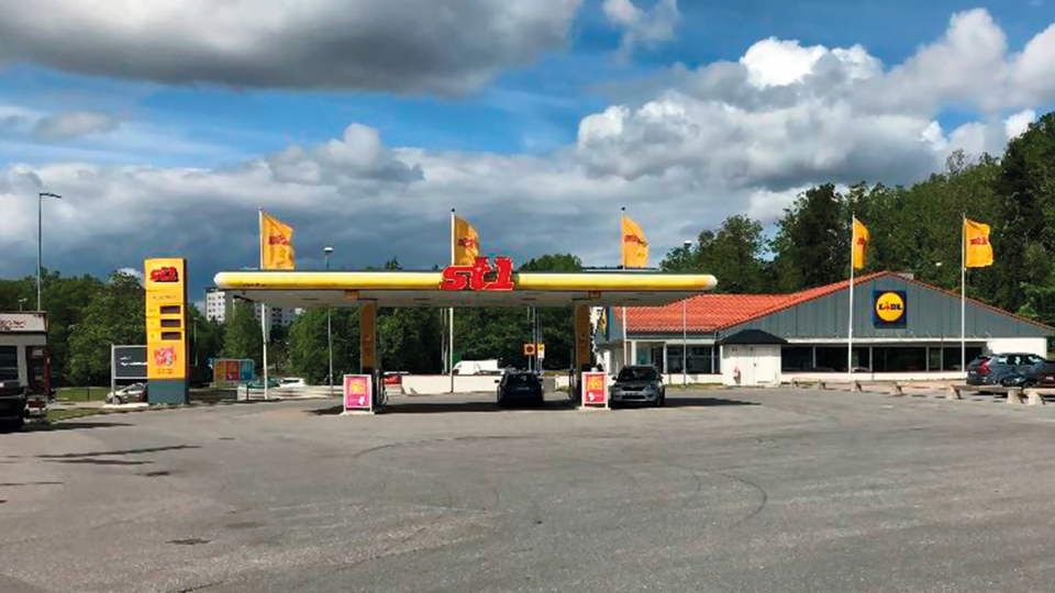 Bensinstationen st1 rakt fram i bild, till höger om den en byggnad med butiken Lidl. Framtill i bild asfalterad yta. Foto