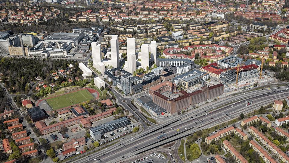 Flygvy över området med föreslagen bebyggelse. Befintlig bebyggelse syns i mitten av bilden och förslagets volymer visas i grått nära Telefonplans tunnelbanestation, fotomontage.