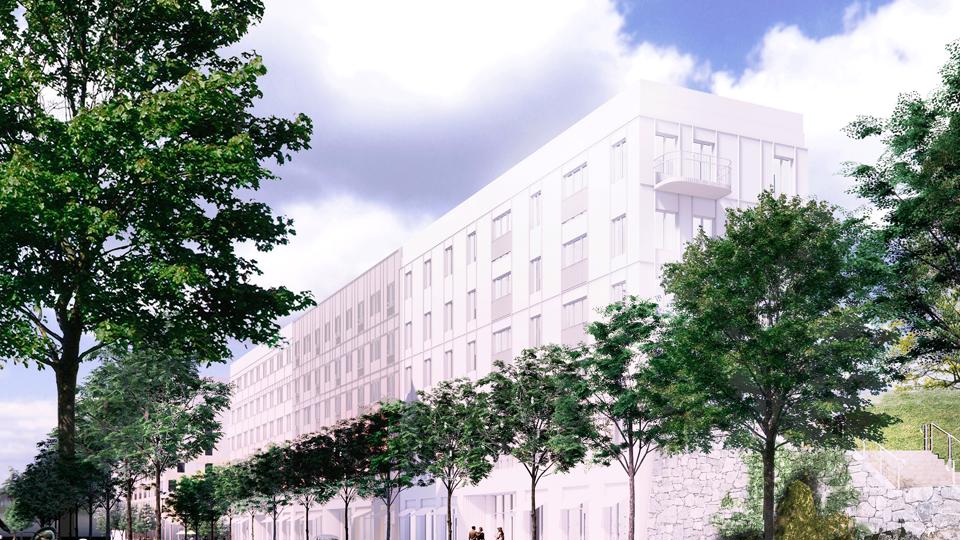 Lamellhuset i kvarter 6 visas längs Mikrofonvägen. Framför huset syns trädrad längs vägen. Till vänster syns ny trappa upp mot Prylvägen och den stadsvilla som också planeras i kvarteret, fotomontage.