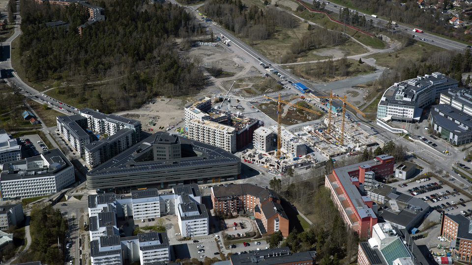 Flygvy över området, lyftkranar, byggarbetsaplats, byggnader, fotografi.