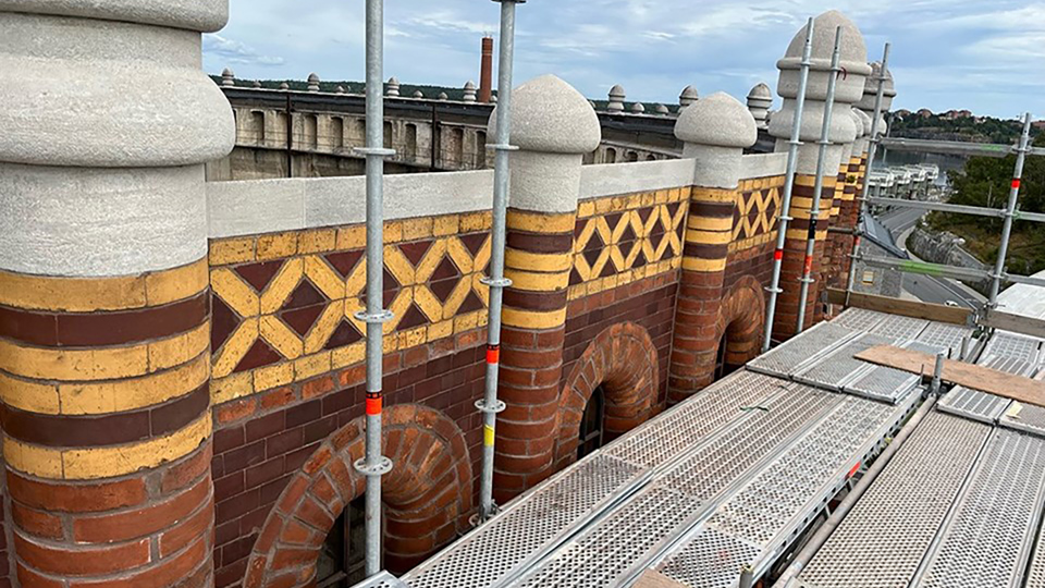 Byggnadsställningar mot gasklockans fasad. Foto.