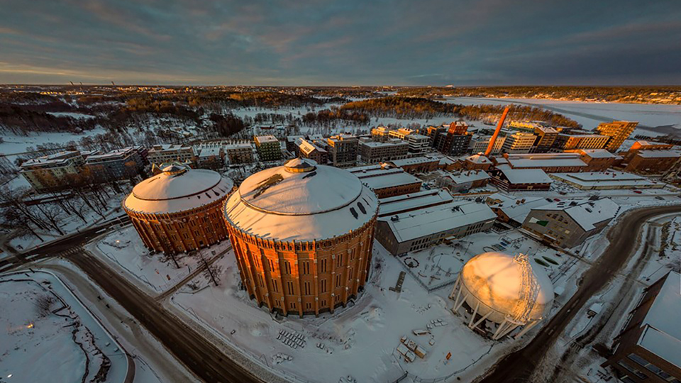 Gasklockor i vintermiljö med omgivande byggnader. Foto.