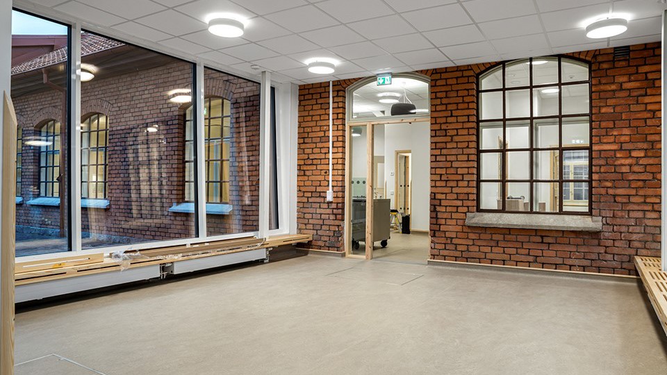 Insida av förskolan, bänkar och stora fönster. Foto.