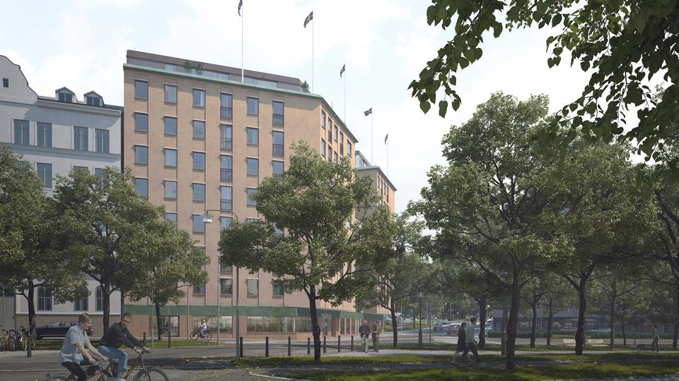 Bild av flerbostadshus sett från marknivå, med cyklister och träd i bilden. 