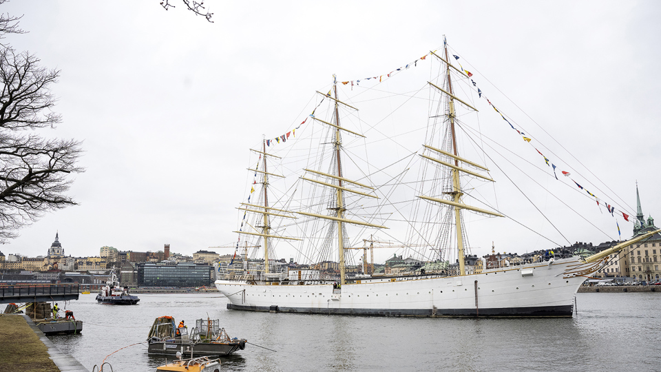 En bogseringsbåt puttar försiktigt skeppet mot kajen vid Skeppsholmen, foto.