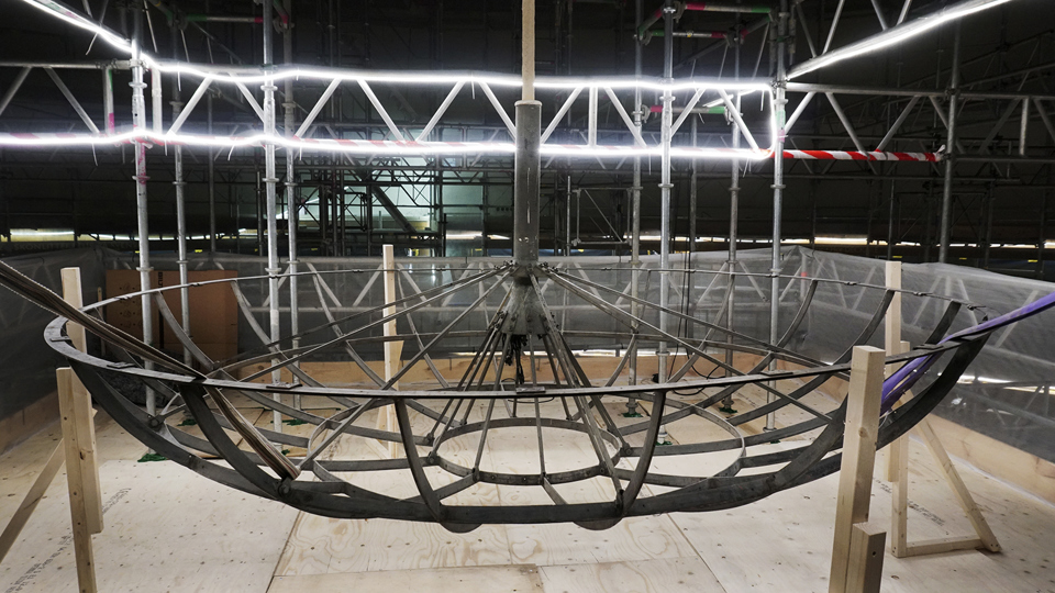 Ljuskronans metallställning har säkrats mot byggställningen i väntan på att delarna ska bli klara.