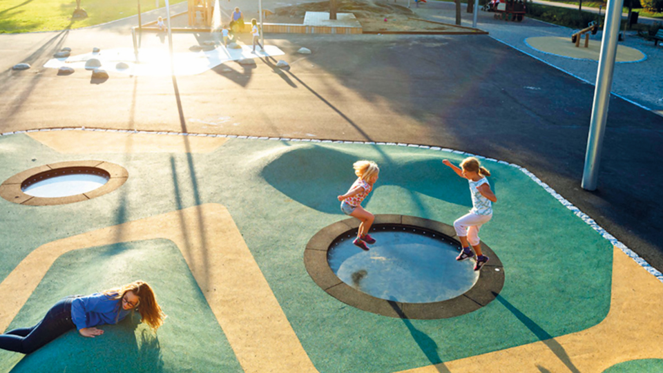 En lekpark med studsmattor och barn som hoppar, foto.