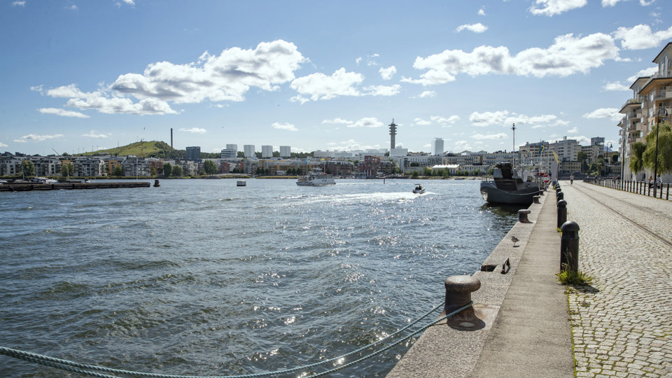 Vy från Norra Hammarbyhamnen med föreslagen bebyggelse i vitt på andra sidan vattnet, fotomontage.