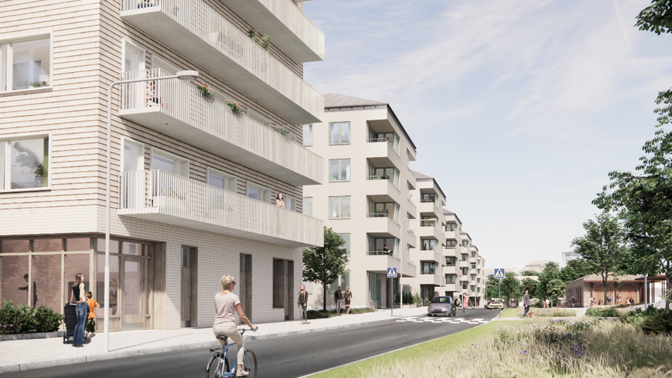 Bostadshus med balkonger placerade längs gata med cyklist. 