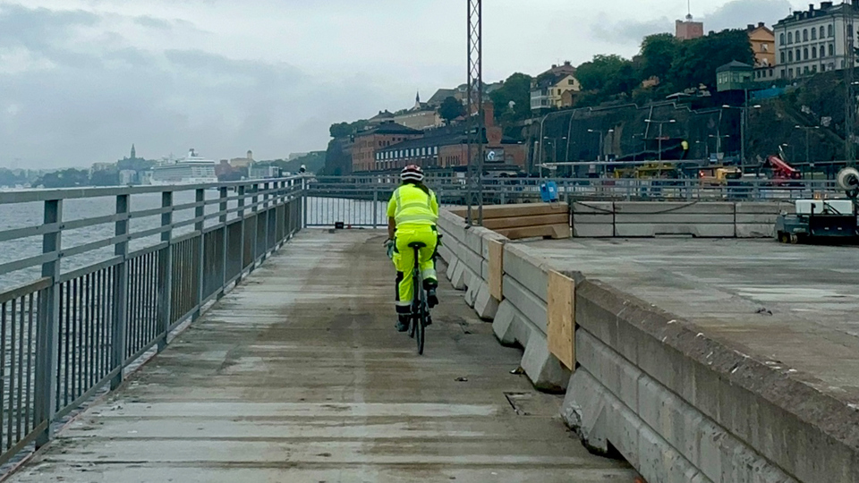 En person cyklar på en cykelbana längs med en ponton på vattnet.