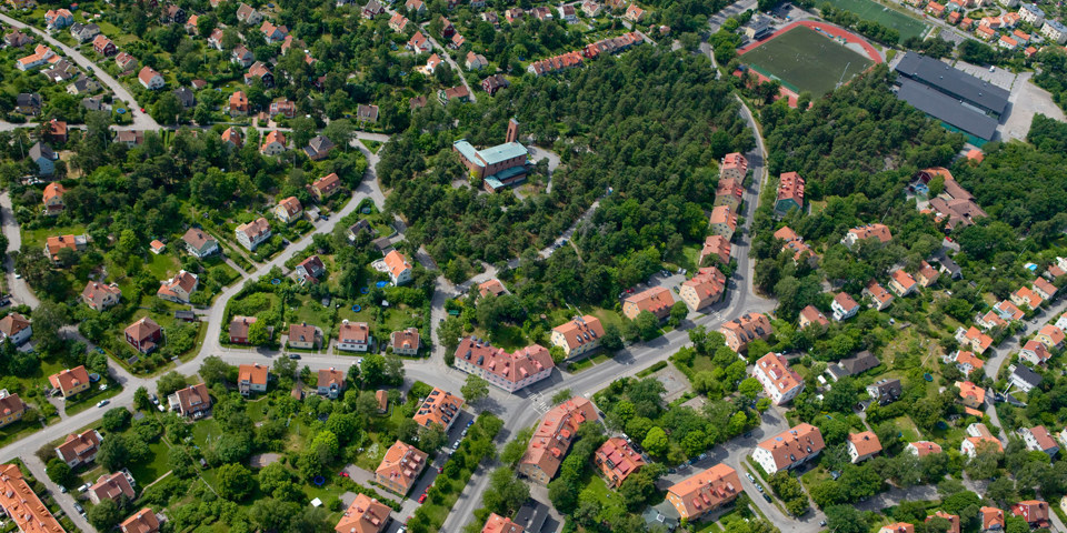 Flygvy över bostadshus och grönområden, foto.