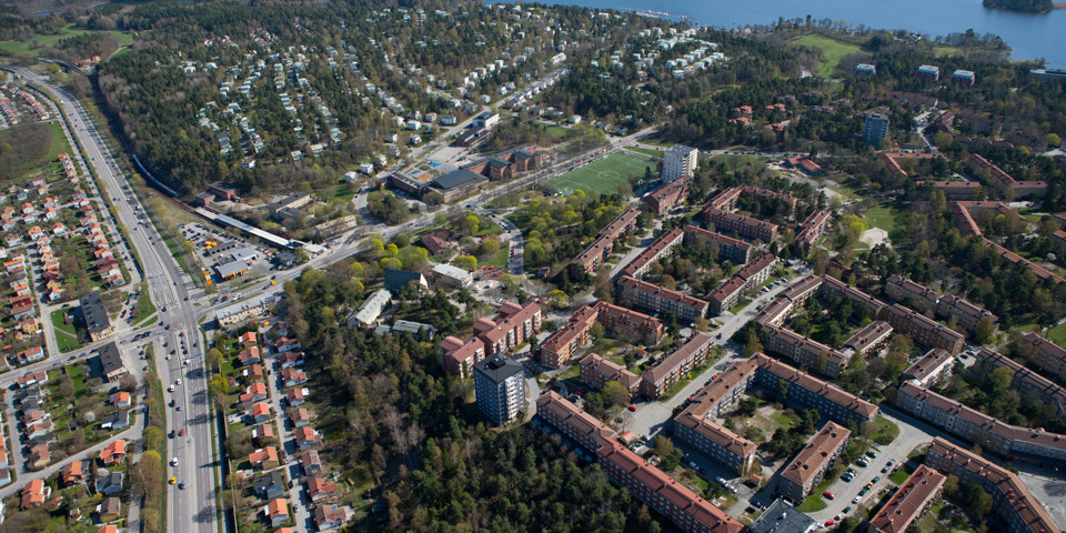 Vy över område med byggnader, vägar och grönområden. Foto.