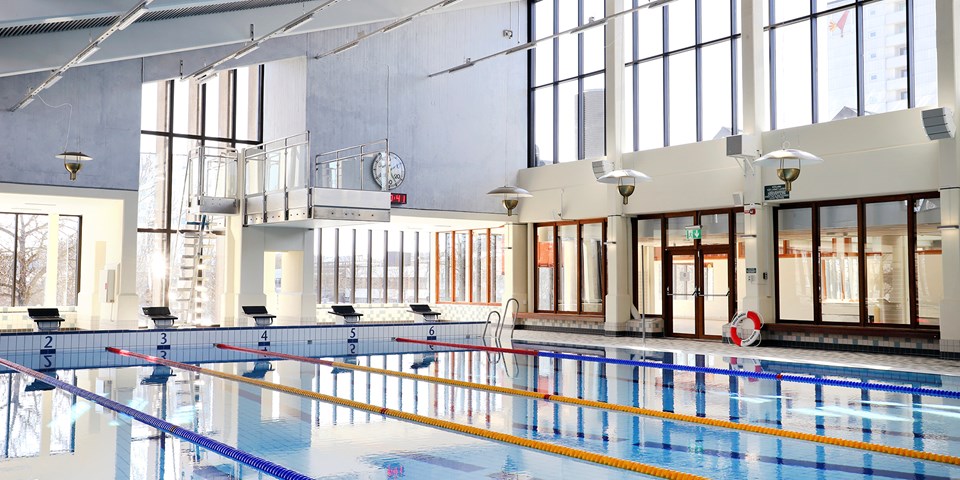 Stor simbassängen i Högdalens simhall med hopptorn och startpallar, foto.