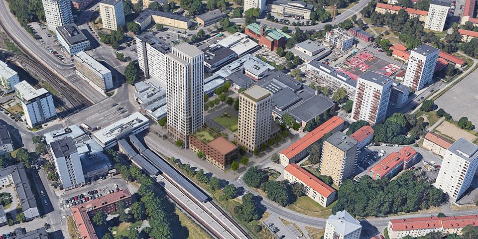 Flygbild över Högdalens centrum mot sydväst. Den föreslagna bebyggelsen i mitten, mellan Sjösavägen, Högdalsgatan och Rangstagatan. Ett torg med grön yta inramat av ny bebyggelse mot Rangstagatan och Sjösavägen. Ett högt punkthus mot tunnelbanestationen och centrum. Ett lite lägre punkthus mot Rangstagatan. 