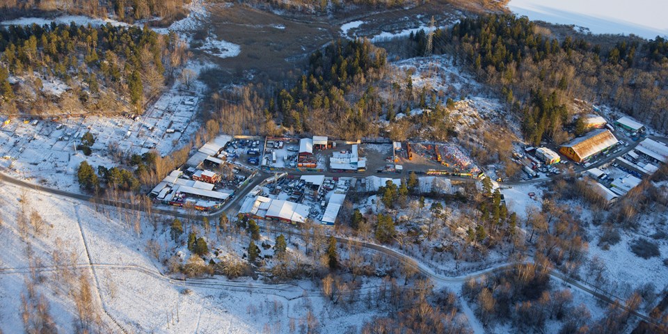 Flygvy över Snösätra industriområde med hus och skog runtom, foto.
