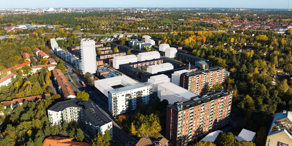 Flyg vy över planområdet med vita hus samt befintliga hus. 