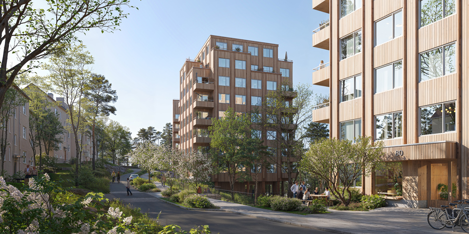 Visionsbild över förslaget sett från den nya gatan. Bilden visar framförallt de två byggnaderna i mitten av förslaget, det västligaste huset skymtas i bakgrunden. Husen är punkthus i trä med indragna balkonger. På de lägre våningsplanen är balkongerna placerade i hörnen. De två översta våningarna har indragna balkonger på husets sidor vilket gör att volymen trappas av uppåt. Den nya gatan visas centralt i bilden. En gångbana går längs gatans högra sida, framför den nya bebyggelsen. På en del av gatan, mellan körbanan och gångbanan finns en planteringsyta. Bakom planteringsytan skymtas en bil, vilket visar att det finns plats för parkering där. Vid planteringsytan, mellan de två byggnaderna, syns räcken och en avsatts i trä vilket är början den föreslagna kopplingen mellan befintligt gångstråk från Gröndalsvägen och den nya gatan. Där finns även en upphöjd övergång över gatan.  