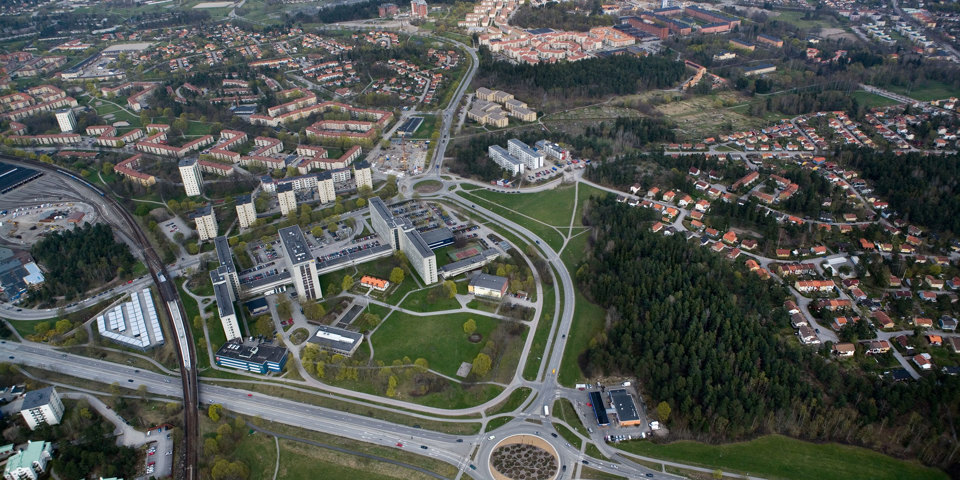 Flygfoto över samhälle. Vägar, hus och grönområden syns. 
