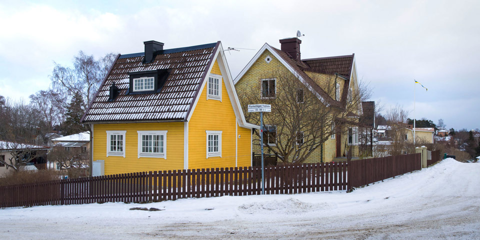 Vy över två villor i gatukorsning. Det är vinter och gatan är snöröjd. Foto.