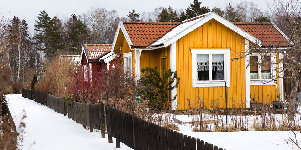 Trävillor med staket och trädgård. Foto.