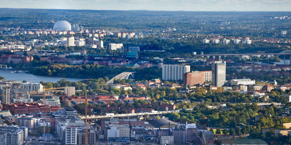 Bostadshus och grönområden omgivet av vatten, foto.