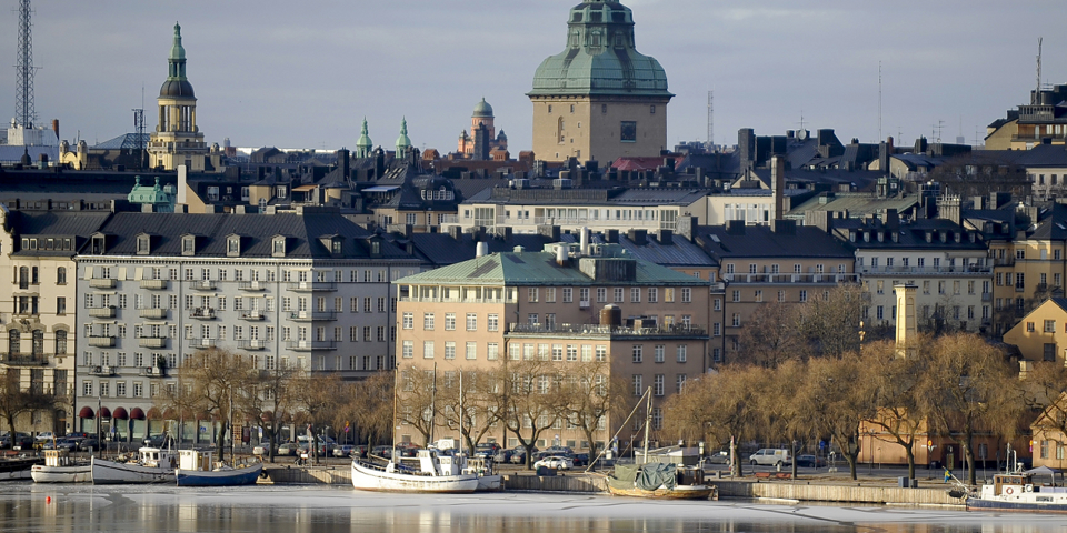 Vy mot kaj, båtar, flerbostadshus och andra byggnader i bakgrunden, fotografi.