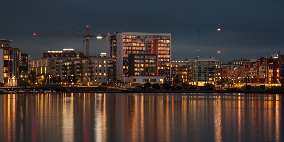 Kvällsvy över bostadshus i Hammarby sjöstad vid vattnet. Foto