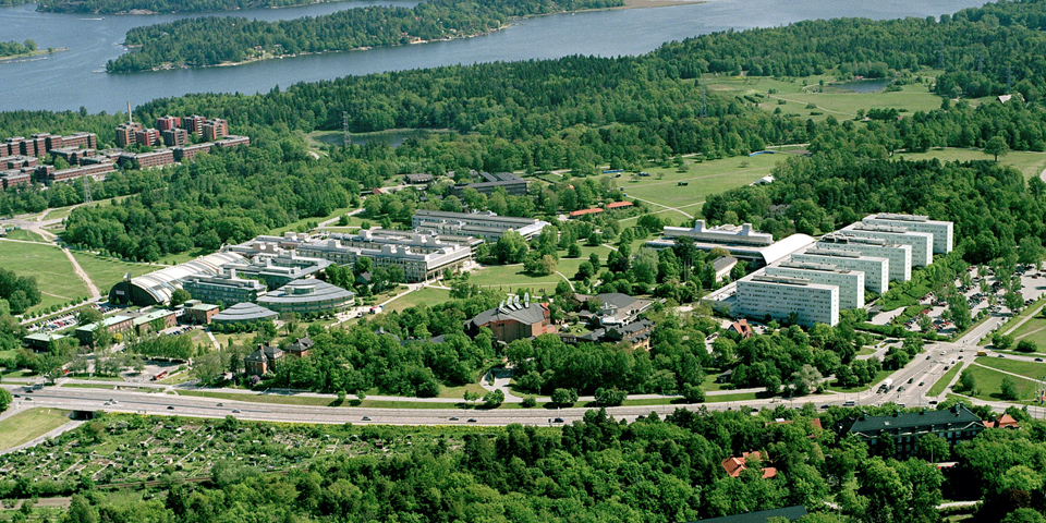 Flygvy över grönområden, vägar, vatten och hus, foto.