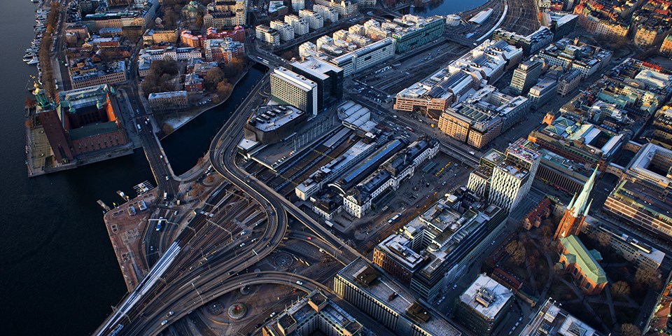 Centralstationen med tågspår och omgivande byggnader, gator, broar och vatten. Flygfoto.
