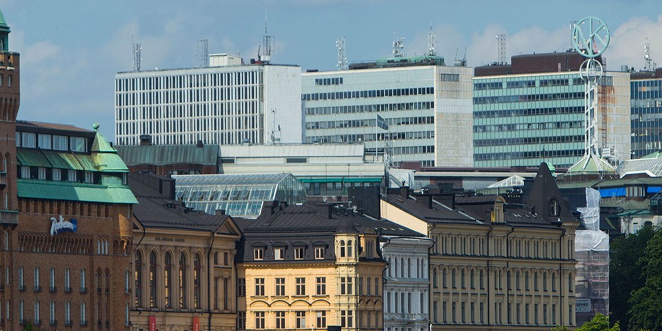 Flervåningshus. I bakgrunden syns Hötorgsskraporna och NK-skylten, foto. 