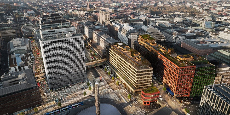Malmskillnadsgatans skyline med hus,  bilvägar, torg, spårvagn och fontän med obelisk. Flygfoto.