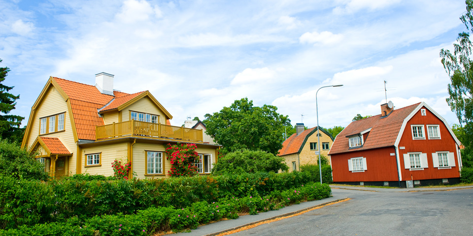 Tre äldre villor i olika färg och storlek, grönska, fotografi.