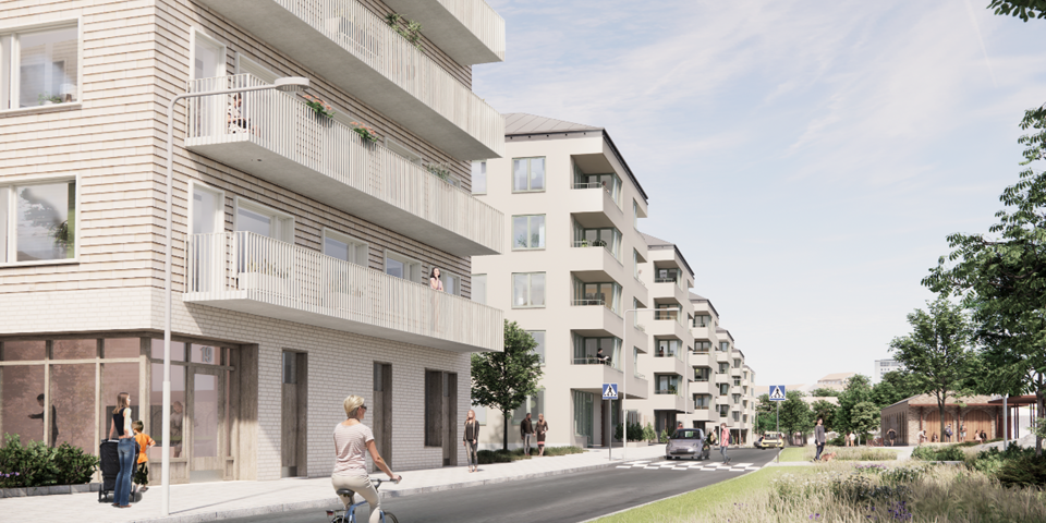 Bostadshus med balkonger placerade längs gata med cyklist. 