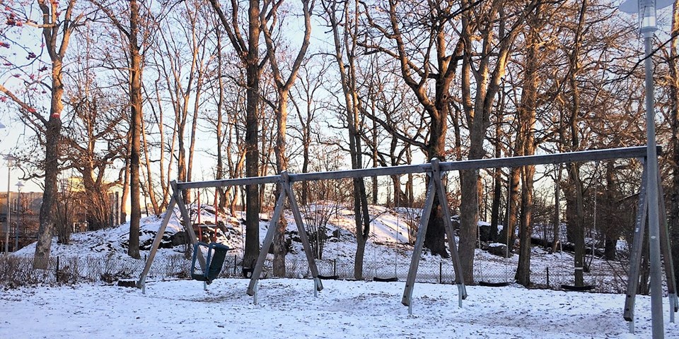 Del av en park, med gungställning och en kulle med träd