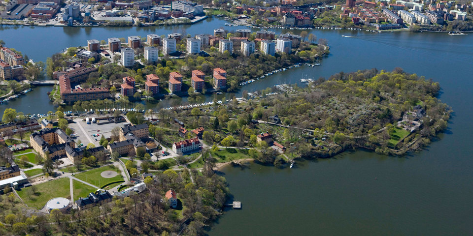Flygvy. Grönområden, bostadsområden och vägar på öar omgärdade av vatten. Foto..