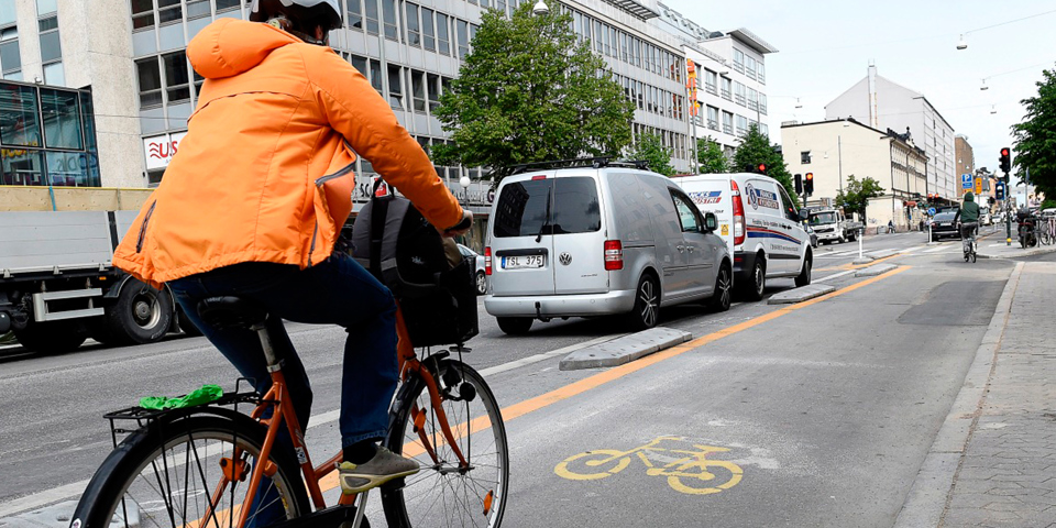 En person som cyklar i cykelbanan parallellt med körbanan på Götgatan, foto.