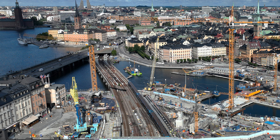 Drönarfoto över Slussenområdet. Vy mot Gamla stan. På vattenområdet mellan öarna pågår byggarbeten.