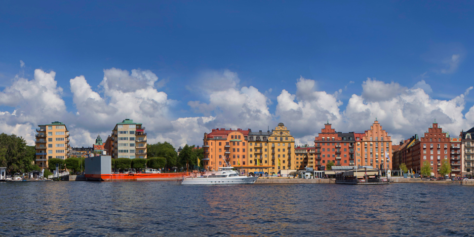 Vy från vattnet in mot norr mälarstrand och de typiska husen i gult, rött och oranget.