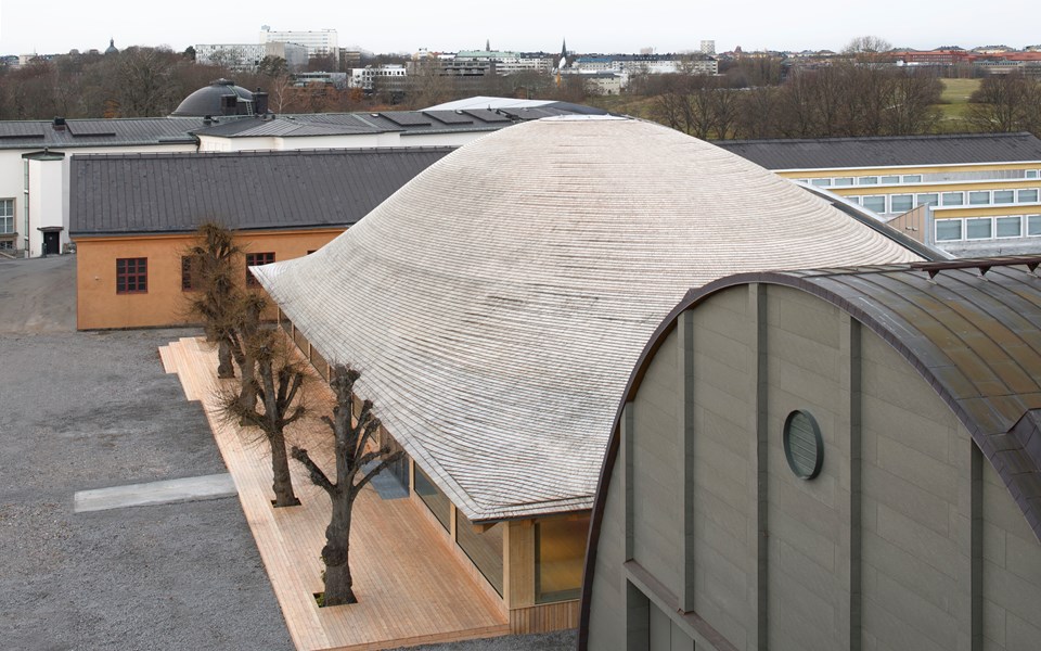 Modern träbyggnad med ett böljande tak, foto.