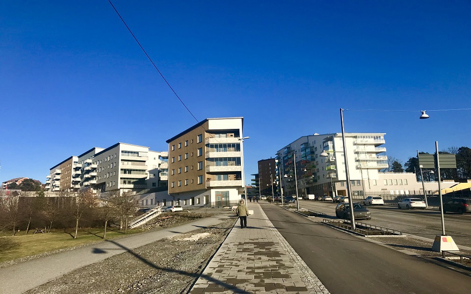 Flera flerbostadshus med både bilväg och promenadväg bredvid.