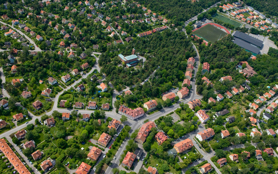 Flygvy över bostadshus och grönområden, foto.