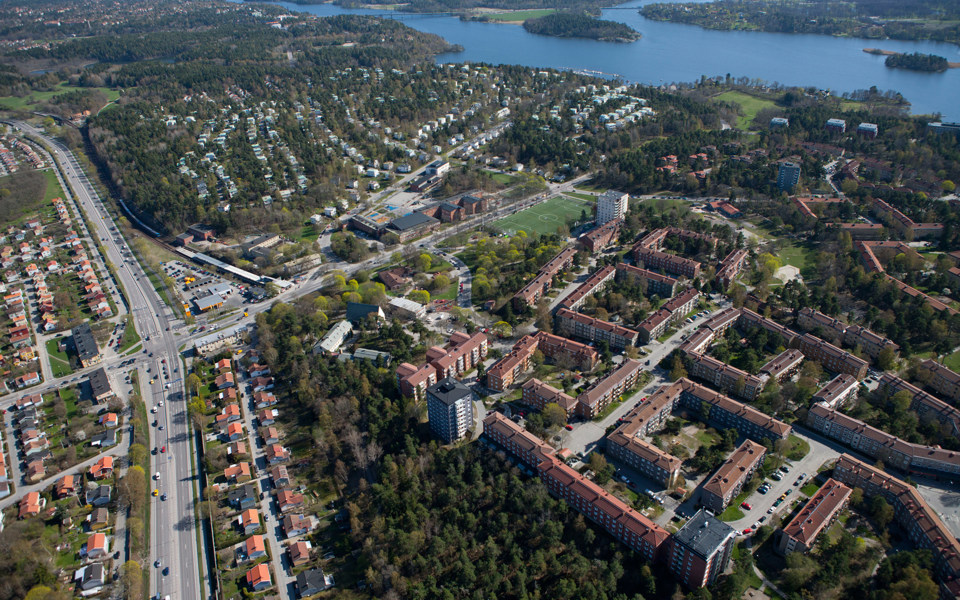 Vy över område med byggnader, vägar och grönområden. Foto.